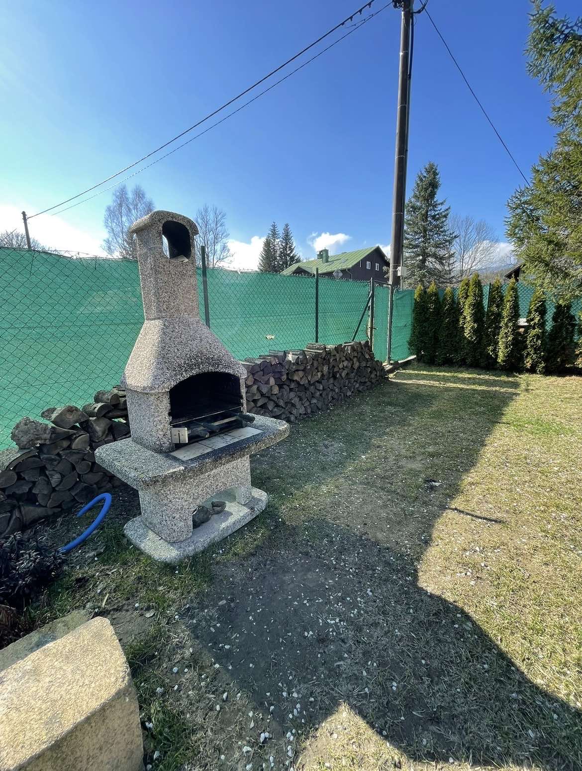 Venkovní krb na oploceném pozemku